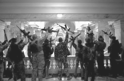 back of people holding guns in the air